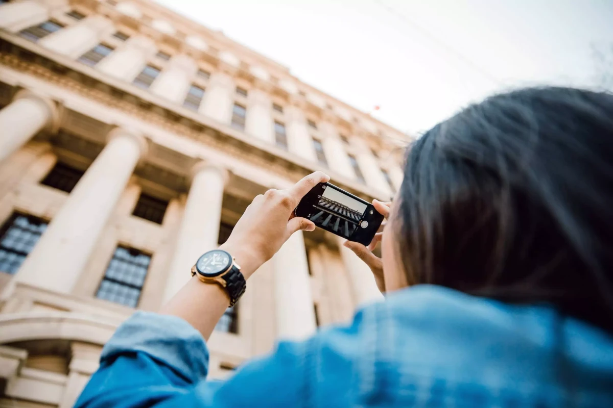 Turist duke bërë fotografi të një ndërtese
